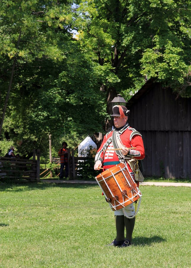 The drummer in vintage military uniform at reenactment of the conflict of Revolutionary War at Black Creek - in June 15 2013 in Black Creek Village, Toronto, Canada. The drummer in vintage military uniform at reenactment of the conflict of Revolutionary War at Black Creek - in June 15 2013 in Black Creek Village, Toronto, Canada
