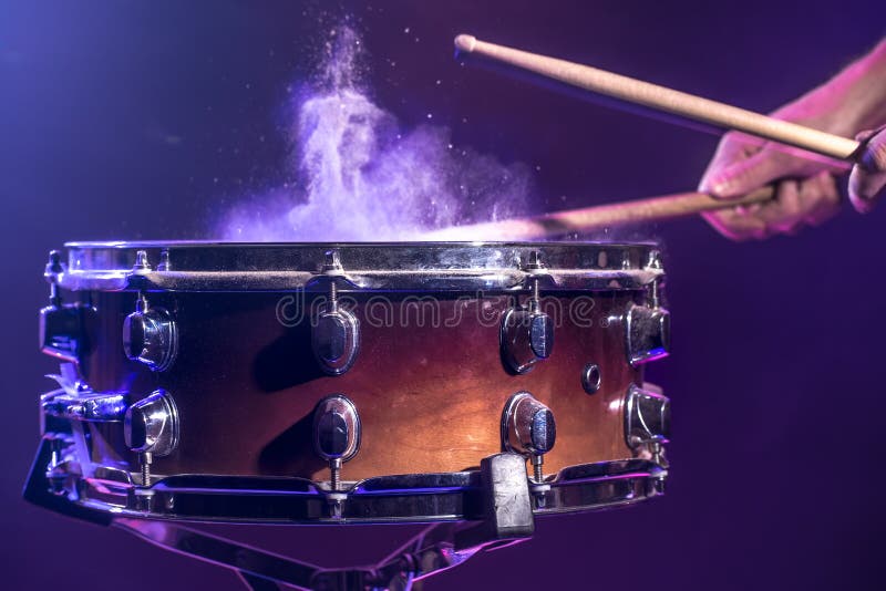 The drummer plays the drums. Beautiful blue and red background, with rays of light. Beautiful special effects smoke and lighting. The drummer plays the drums. Beautiful blue and red background, with rays of light. Beautiful special effects smoke and lighting