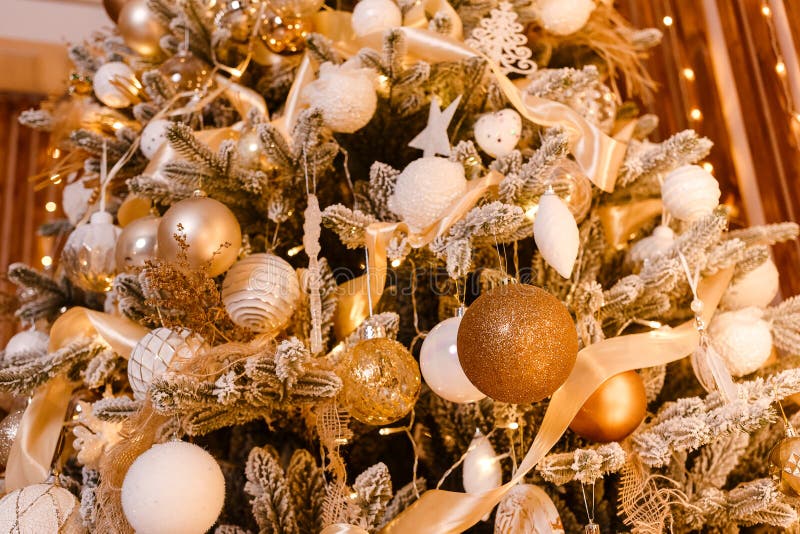 Il bel albero di Natale è vicino. Natale d'oro. Palle d'oro e bianco sui rami dell'albero di Natale fotografie stock libere da diritti
