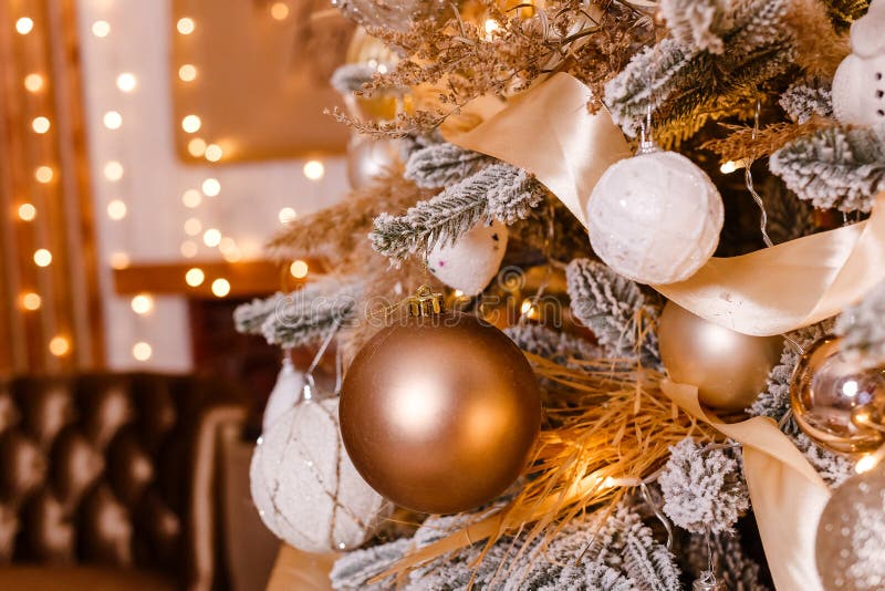 Il bel albero di Natale è vicino. Natale d'oro. Palle d'oro e bianco sui rami dell'albero di Natale fotografia stock