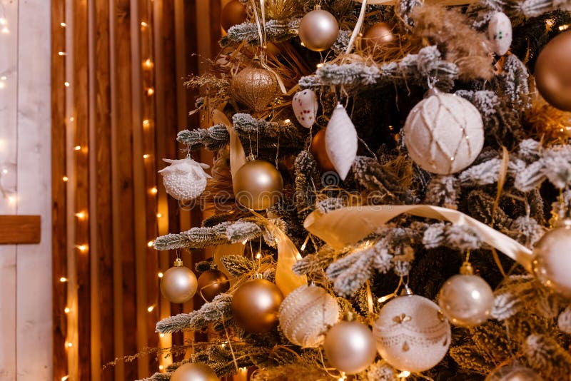 Il bel albero di Natale è vicino. Natale d'oro. Palle d'oro e bianco sui rami dell'albero di Natale fotografia stock