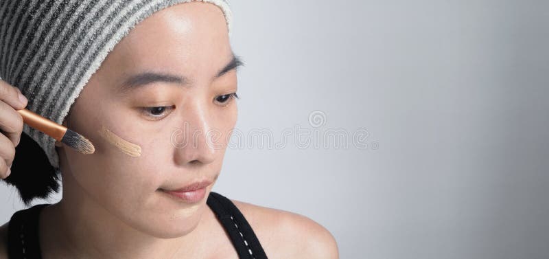 Il bello fronte della donna asiatica compone dal liquido del fondamento fotografia stock libera da diritti Il bello fronte della donna asiatica compone dal liquido del fondamento fotografia stock libera da diritti