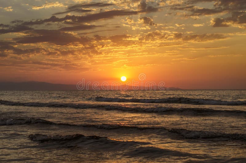 Il bello paesaggio ardente del tramonto in mare il mar Caspio ed il cielo arancio sopra con la riflessione dorata del sole impres fotografia stock Il bello paesaggio ardente del tramonto in mare il mar Caspio ed il cielo arancio sopra con la riflessione dorata del sole impres fotografia stock