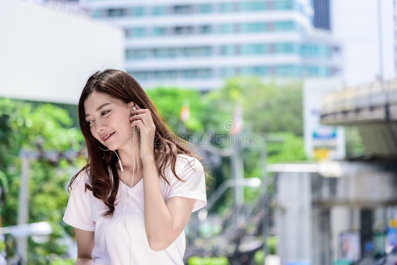 Il bello turista asiatico della donna ha musica che ascolta con la cuffia fotografia stock libera da diritti Il bello turista asiatico della donna ha musica che ascolta con la cuffia fotografia stock libera da diritti