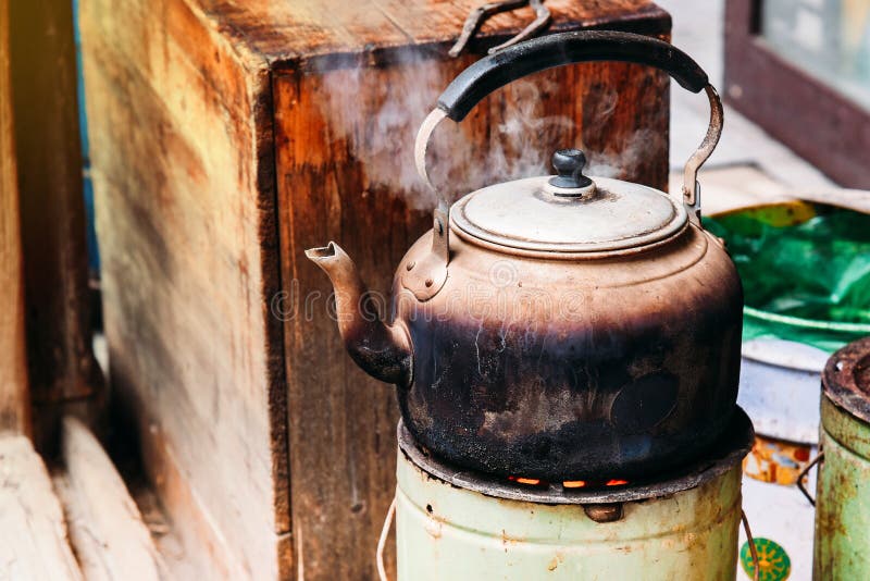 Il bollitore di tè in alluminio è sulla stufa L'acqua bolle e il fumo galleggia immagini stock libere da diritti Il bollitore di tè in alluminio è sulla stufa L'acqua bolle e il fumo galleggia immagini stock libere da diritti