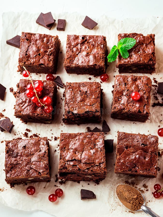 Il brownie collega con i dadi decorati con le bacche e le foglie di menta sul Libro Bianco immagini stock libere da diritti Il brownie collega con i dadi decorati con le bacche e le foglie di menta sul Libro Bianco immagini stock libere da diritti