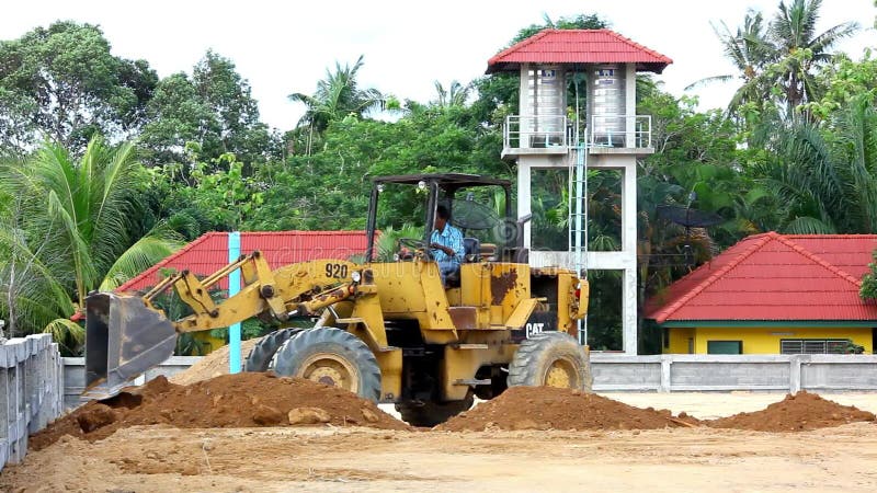 Il bulldozer della scavatrice che fa il movimento terra funziona all'aperto