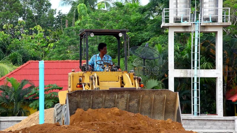 Il bulldozer della scavatrice che fa il movimento terra funziona all'aperto