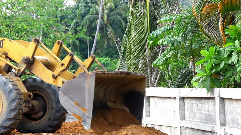 Il bulldozer della scavatrice che fa il movimento terra funziona all'aperto