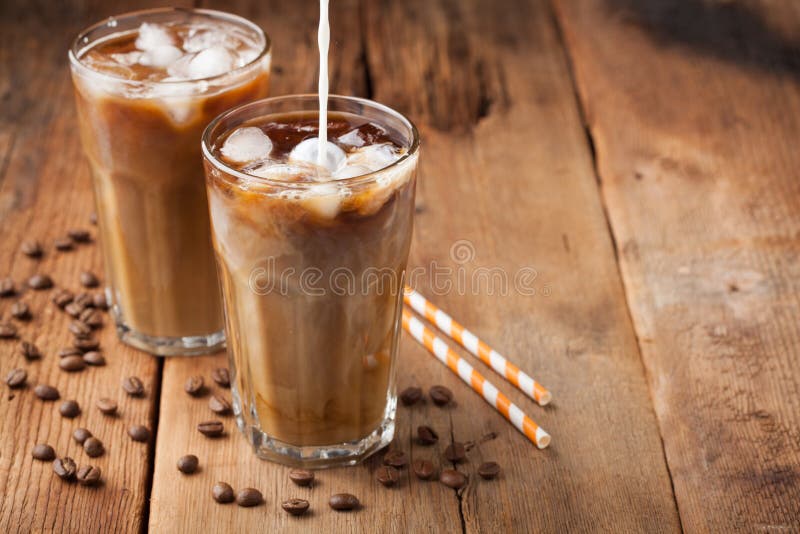 Il caffè di ghiaccio in un vetro alto con crema ha versato più e chicchi di caffè su una vecchia tavola di legno rustica Bevanda immagine stock Il caffè di ghiaccio in un vetro alto con crema ha versato più e chicchi di caffè su una vecchia tavola di legno rustica Bevanda immagine stock