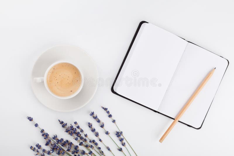 Il caffè, il taccuino pulito e la lavanda fioriscono sulla tavola bianca da sopra Scrittorio funzionante della donna Modello acco immagini stock libere da diritti