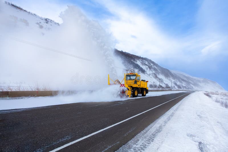 Il camion giallo dello spazzaneve o il camion di rimozione di neve con la lama dello spazzaneve sta rimuovendo la neve dalla stra immagine stock Il camion giallo dello spazzaneve o il camion di rimozione di neve con la lama dello spazzaneve sta rimuovendo la neve dalla stra immagine stock