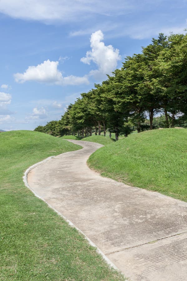 Il campo da golf curvo di verde di via e la bella scena della natura fotografia stock libera da diritti Il campo da golf curvo di verde di via e la bella scena della natura fotografia stock libera da diritti