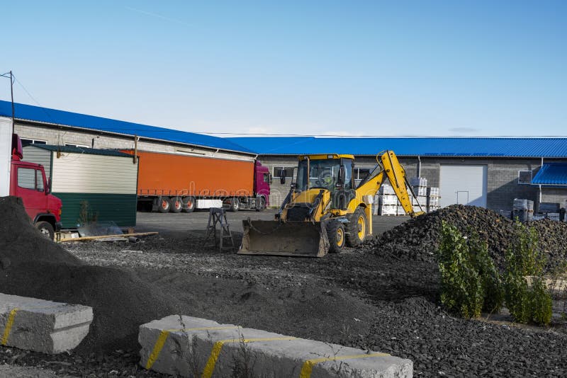Il caricatore di backhoe giallo a trazione integrale si trova sul cantiere pronto per la lavorazione sul cantiere immagini stock Il caricatore di backhoe giallo a trazione integrale si trova sul cantiere pronto per la lavorazione sul cantiere immagini stock
