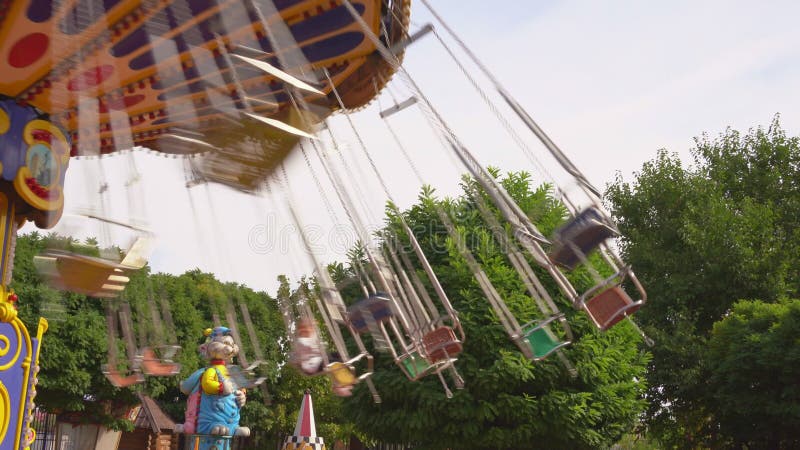 Il carosello della catena gira nel parco divertimenti. ragazze che cavalcano durante il weekend. archivi video