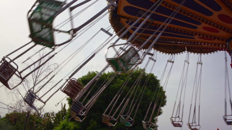 Il carosello della catena gira nel parco divertimenti ragazze che cavalcano durante il weekend video d archivio