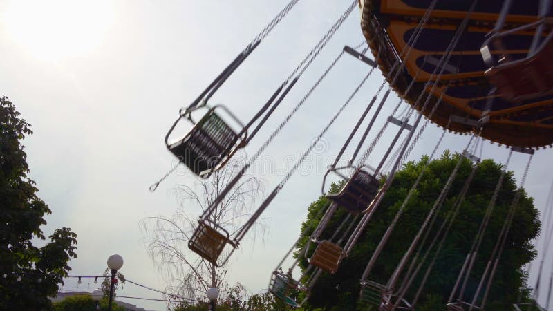 Il carosello della catena gira nel parco divertimenti. ragazze che cavalcano durante il weekend stock footage