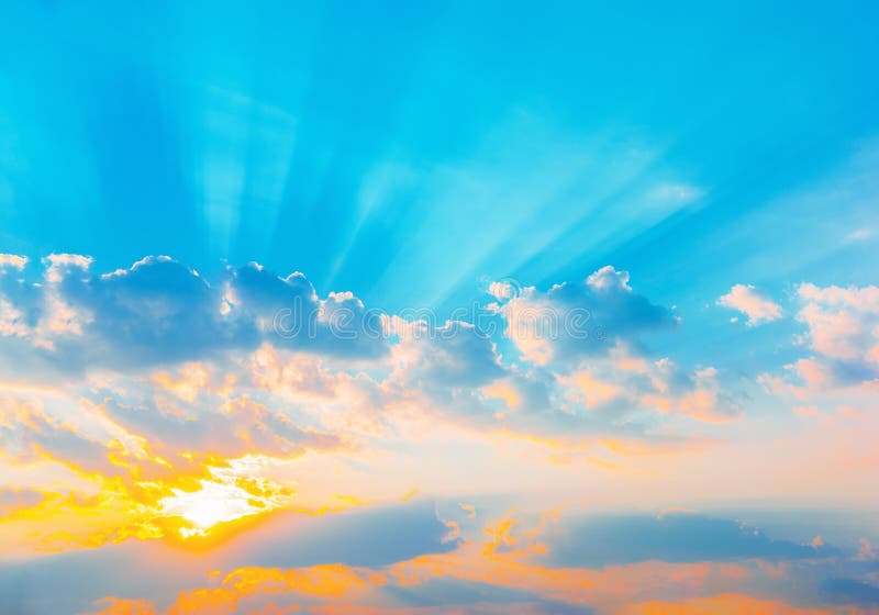 Il cielo blu drammatico dell'alba con il sole arancio rays attraversare le nuvole Priorità bassa della natura Concetto di speranz