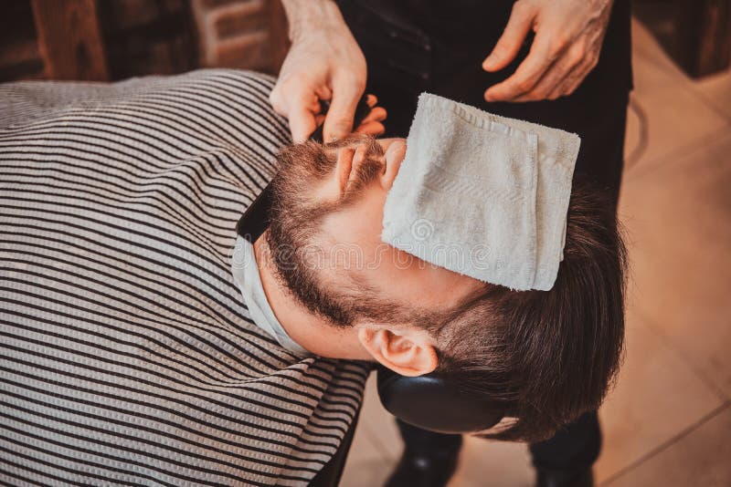 Il cliente barbuto ha ottenuto appena il buon beardcare dal barbiere d'avanguardia immagine stock Il cliente barbuto ha ottenuto appena il buon beardcare dal barbiere d'avanguardia immagine stock