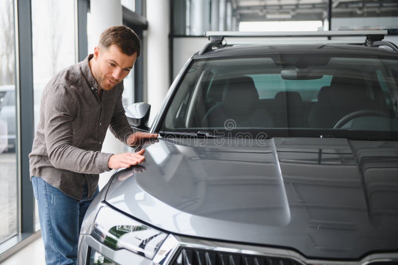 Il cliente esamina la nuova auto in una vetrina di concessionari fotografie stock libere da diritti