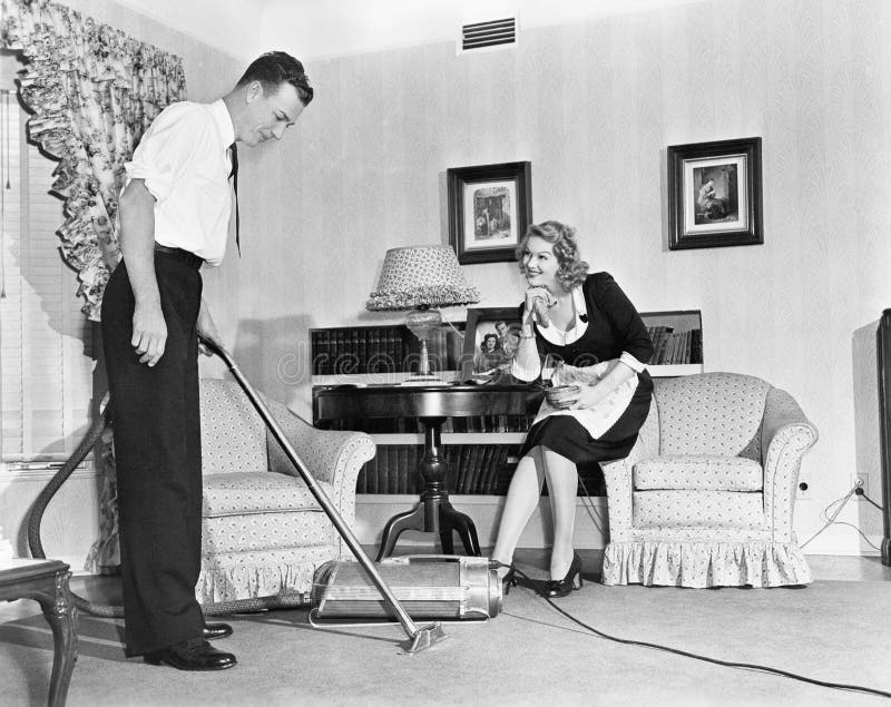 Il commesso dimostra un aspirapolvere ad una casalinga nella sua casa (tutte le persone rappresentate non sono vivente più lungo