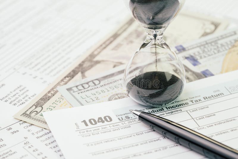 Il concetto di tempo di imposta ad aprile, rinchiude del 1040 la forma di riempimento dell'imposta sul reddito delle persone fisi immagine stock Il concetto di tempo di imposta ad aprile, rinchiude del 1040 la forma di riempimento dell'imposta sul reddito delle persone fisi immagine stock