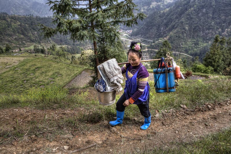 Il contadino cinese della lavoratrice agricola ha il peso sulla vostra spalla fotografia stock libera da diritti Il contadino cinese della lavoratrice agricola ha il peso sulla vostra spalla fotografia stock libera da diritti