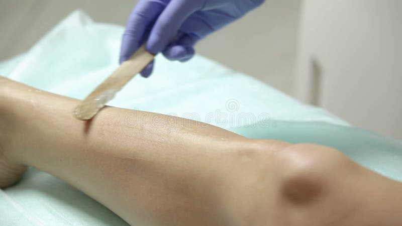 Il cosmetologo applica il gel ai piedi pazienti del ` s prima della procedura di epilation