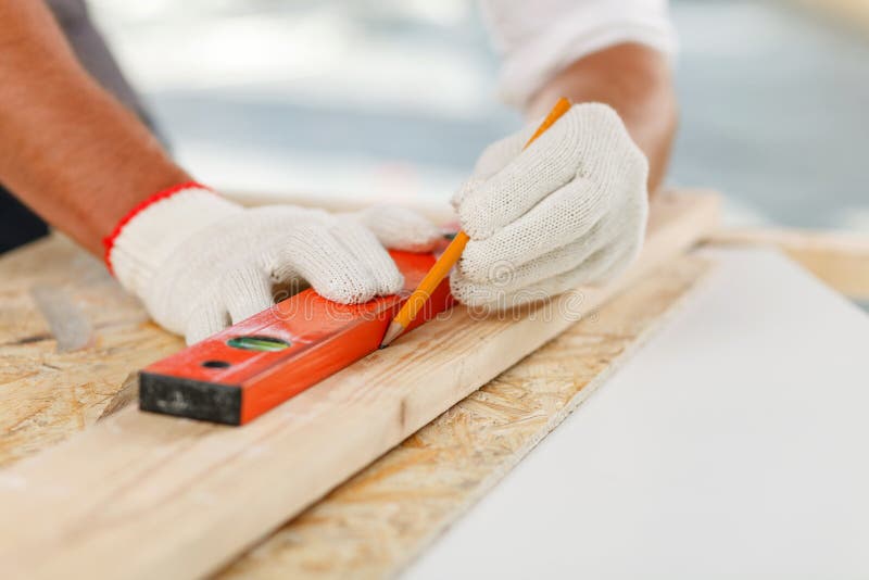 Il costruttore maschio professionista è misurare di legno immagine stock Il costruttore maschio professionista è misurare di legno immagine stock