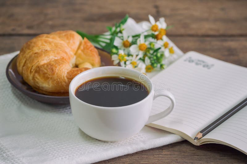 Il croissant casalingo è servito con caffè nero o il americano Delici fotografia stock Il croissant casalingo è servito con caffè nero o il americano Delici fotografia stock
