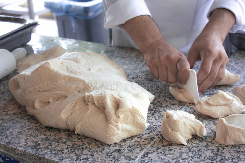 Il cuoco del cuoco unico lavora con una pasta di lievito fotografia stock Il cuoco del cuoco unico lavora con una pasta di lievito fotografia stock