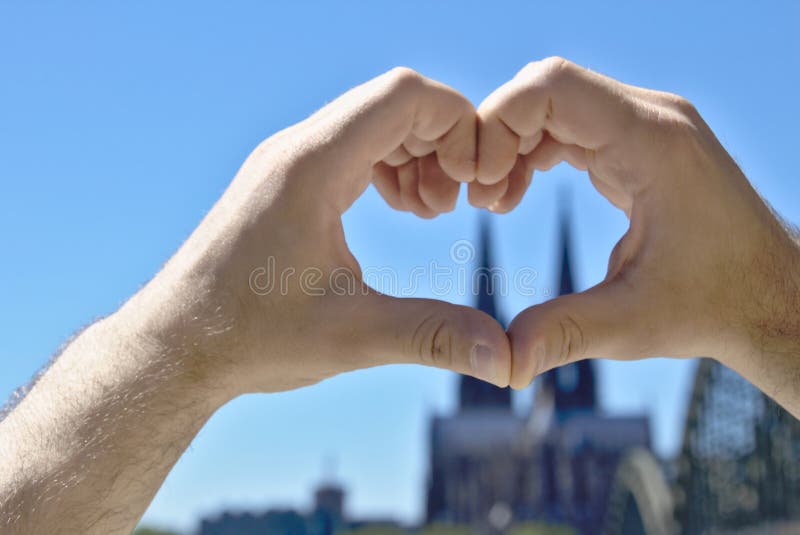 Il cuore ha fatto delle mani davanti alla cattedrale di Colonia immagini stock Il cuore ha fatto delle mani davanti alla cattedrale di Colonia immagini stock