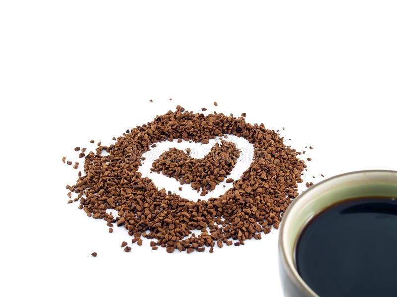 Il cuore ha modellato sulla polvere del caffè istantaneo e su una tazza di caffè immagini stock Il cuore ha modellato sulla polvere del caffè istantaneo e su una tazza di caffè immagini stock
