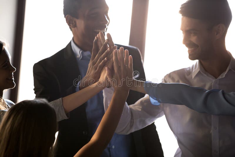 Il diverso gruppo felice di affari dà alti cinque motivati da successo fotografia stock libera da diritti Il diverso gruppo felice di affari dà alti cinque motivati da successo fotografia stock libera da diritti