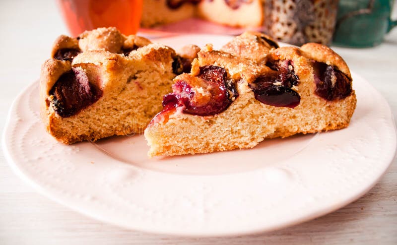Il dolce rotondo dolce casalingo New York Times della prugna cutted sul piatto con le tazze, i vetri di tè, il caffè alla parte p immagini stock libere da diritti Il dolce rotondo dolce casalingo New York Times della prugna cutted sul piatto con le tazze, i vetri di tè, il caffè alla parte p immagini stock libere da diritti