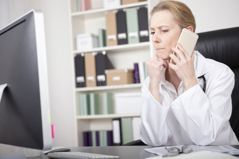 Il dottore Listening della donna a qualcuno sopra il telefono fotografie stock Il dottore Listening della donna a qualcuno sopra il telefono fotografie stock