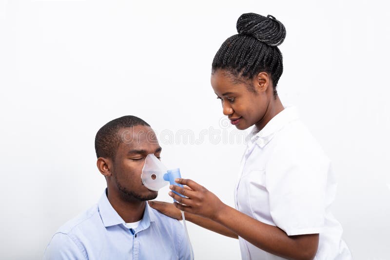 Il dottore Placing Inhaler Mask sulla bocca dell'uomo fotografie stock libere da diritti Il dottore Placing Inhaler Mask sulla bocca dell'uomo fotografie stock libere da diritti