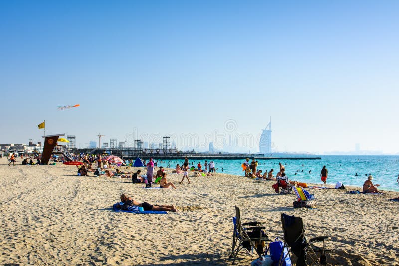 Il Dubai, Emirati Arabi Uniti, il 20 aprile 2018: Spiaggia dell'aquilone nel Dubai con molti ospiti ed hotel di Burj Al Arab nei fotografia stock libera da diritti Il Dubai, Emirati Arabi Uniti, il 20 aprile 2018: Spiaggia dell'aquilone nel Dubai con molti ospiti ed hotel di Burj Al Arab nei fotografia stock libera da diritti