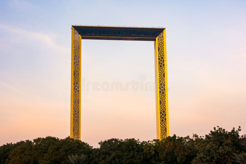 Il Dubai, Emirati Arabi Uniti, l'11 febbraio 2018: Costruzione della pagina del Dubai con le palme al tramonto La struttura misur fotografie stock libere da diritti Il Dubai, Emirati Arabi Uniti, l'11 febbraio 2018: Costruzione della pagina del Dubai con le palme al tramonto La struttura misur fotografie stock libere da diritti