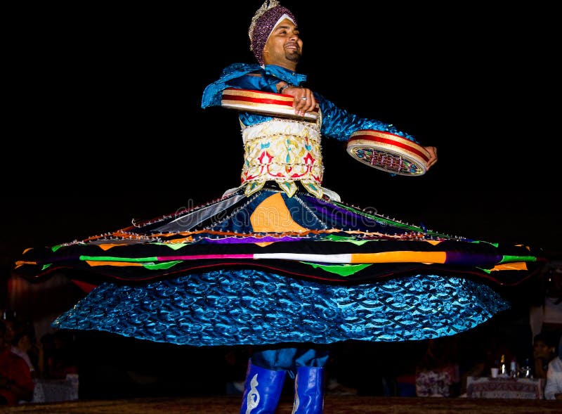 IL DUBAI, UAE - 20 APRILE 2012: Un uomo che esegue danza popolare tradizionale alla notte fotografia stock libera da diritti IL DUBAI, UAE - 20 APRILE 2012: Un uomo che esegue danza popolare tradizionale alla notte fotografia stock libera da diritti