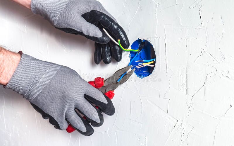 Il electrician& x27; le mani di s con pasatises puliscono i cavi in una scatola di giunzione immagini stock libere da diritti Il electrician& x27; le mani di s con pasatises puliscono i cavi in una scatola di giunzione immagini stock libere da diritti