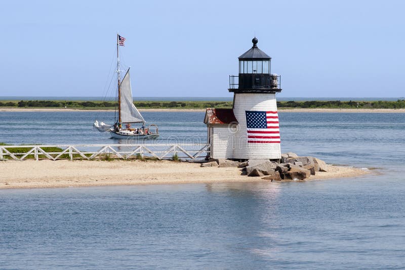 Il faro patriottico guida una barca a vela dall'isola H di Nantucket fotografia stock libera da diritti Il faro patriottico guida una barca a vela dall'isola H di Nantucket fotografia stock libera da diritti