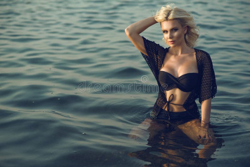 Il fascino splendido ha abbronzato la donna bionda che indossa la tunica senza spalline in due pezzi nera d'avanguardia dell'esta fotografia stock libera da diritti Il fascino splendido ha abbronzato la donna bionda che indossa la tunica senza spalline in due pezzi nera d'avanguardia dell'esta fotografia stock libera da diritti