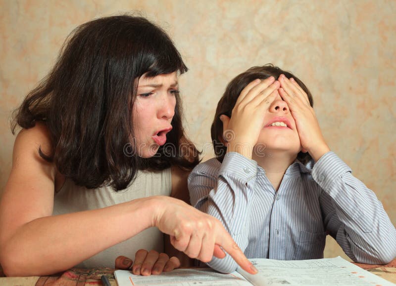 Il figlio di aiuto della mamma fa il compito difficile fotografia stock Il figlio di aiuto della mamma fa il compito difficile fotografia stock
