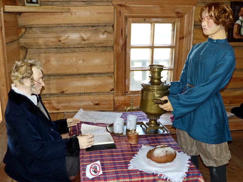 Il figlio più anziano del proprietario porta ad ospiti la samovar Lo scienziato scrive qualcosa in suo diario Alla locanda immagine stock Il figlio più anziano del proprietario porta ad ospiti la samovar Lo scienziato scrive qualcosa in suo diario Alla locanda immagine stock