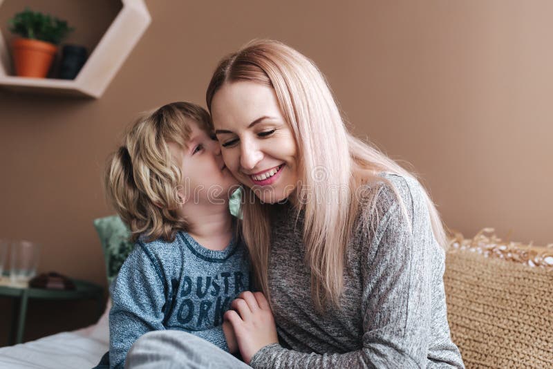Il figlio sta baciando sua madre Mamma e figlio Giorno felice del `s della madre Madre che abbraccia il suo bambino a casa fotografia stock Il figlio sta baciando sua madre Mamma e figlio Giorno felice del `s della madre Madre che abbraccia il suo bambino a casa fotografia stock