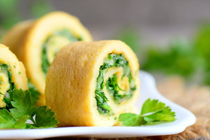 Il formaggio e le erbe casalinghi hanno farcito l'omelette Tagli l'omelette con formaggio grattugiato e le erbe finemente tritate fotografia stock Il formaggio e le erbe casalinghi hanno farcito l'omelette Tagli l'omelette con formaggio grattugiato e le erbe finemente tritate fotografia stock
