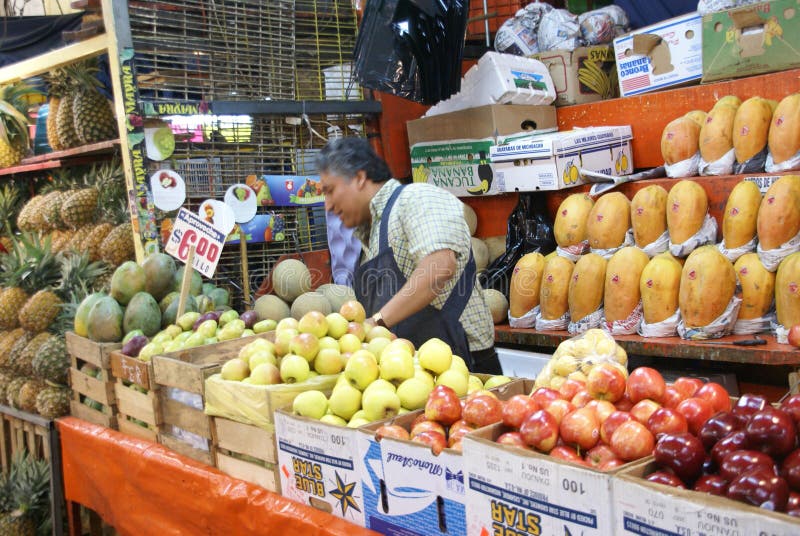 MEXICO CITY - SEP 4, 2008 - Fruit stall vendor tends his produce in the Merced Market in central Mexico City. MEXICO CITY - SEP 4, 2008 - Fruit stall vendor tends his produce in the Merced Market in central Mexico City.