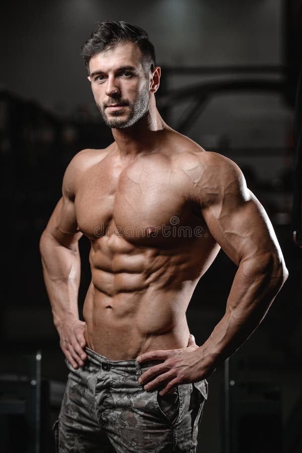 Il forte e giovane atletico bello muscles l'ABS ed il bicipite fotografia stock Il forte e giovane atletico bello muscles l'ABS ed il bicipite fotografia stock