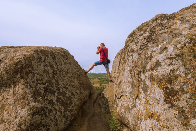 Il fotografo prende le immagini della natura, stanti sopra una scogliera immagini stock Il fotografo prende le immagini della natura, stanti sopra una scogliera immagini stock